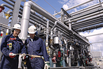 Men standing in front of chemical plant