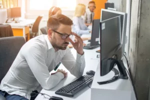 Worried Quickbooks businessman looking at computer screen at his workplace