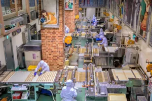 A group of workers working in a Bakery factory and using Panni bakery ERP software in Canada