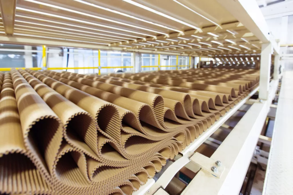 Closeup image of pleat cardboard row at factory background - packaging industry's packaging efficiency